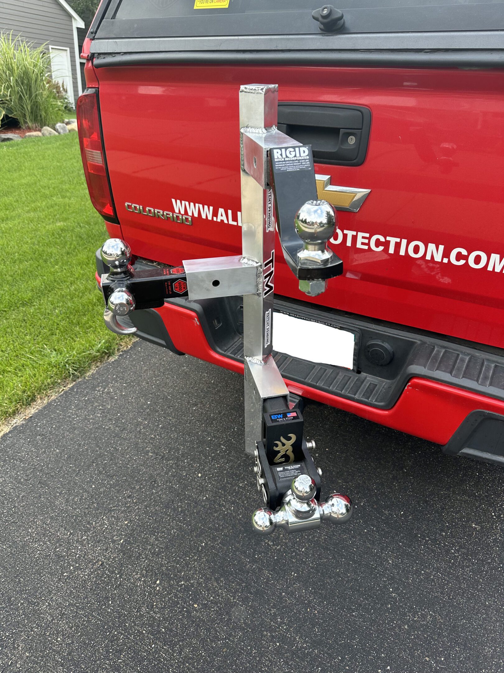 Red truck with a complex trailer hitch and electrical connections.