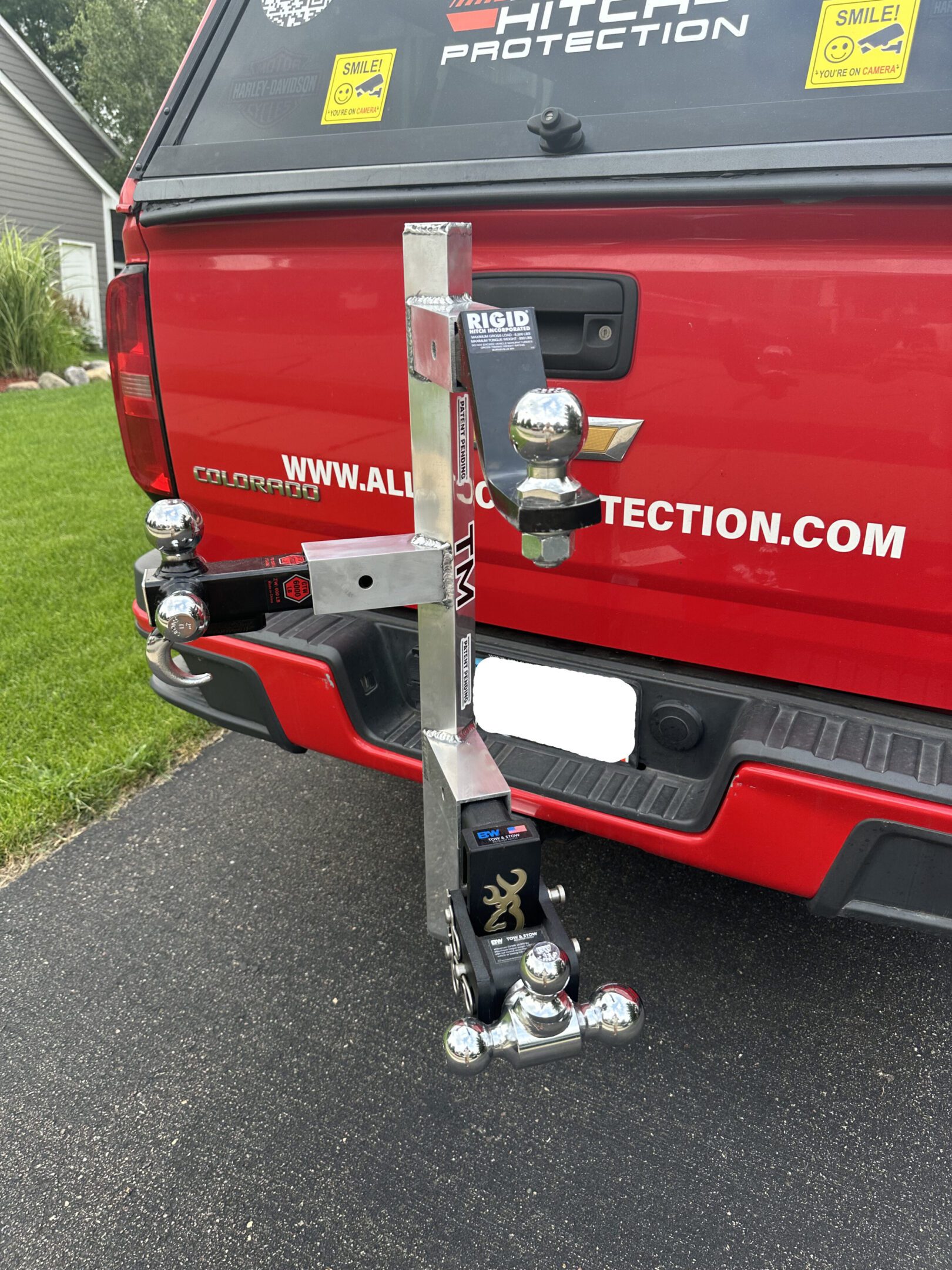 Custom hitch with multiple trailer ball sizes attached to a red truck.