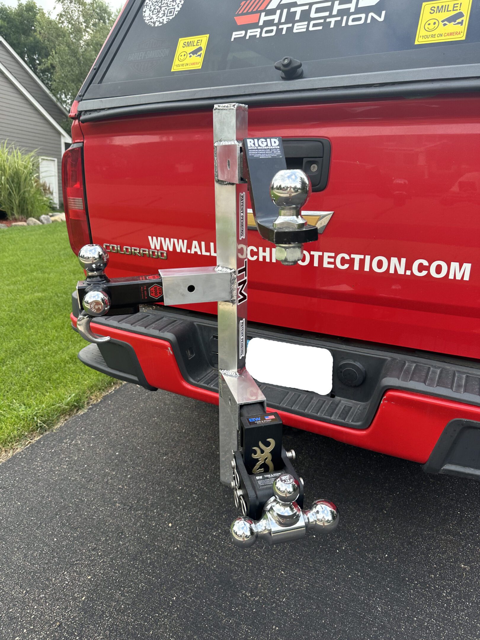 A red truck with a hitch and equipment attached at the rear.