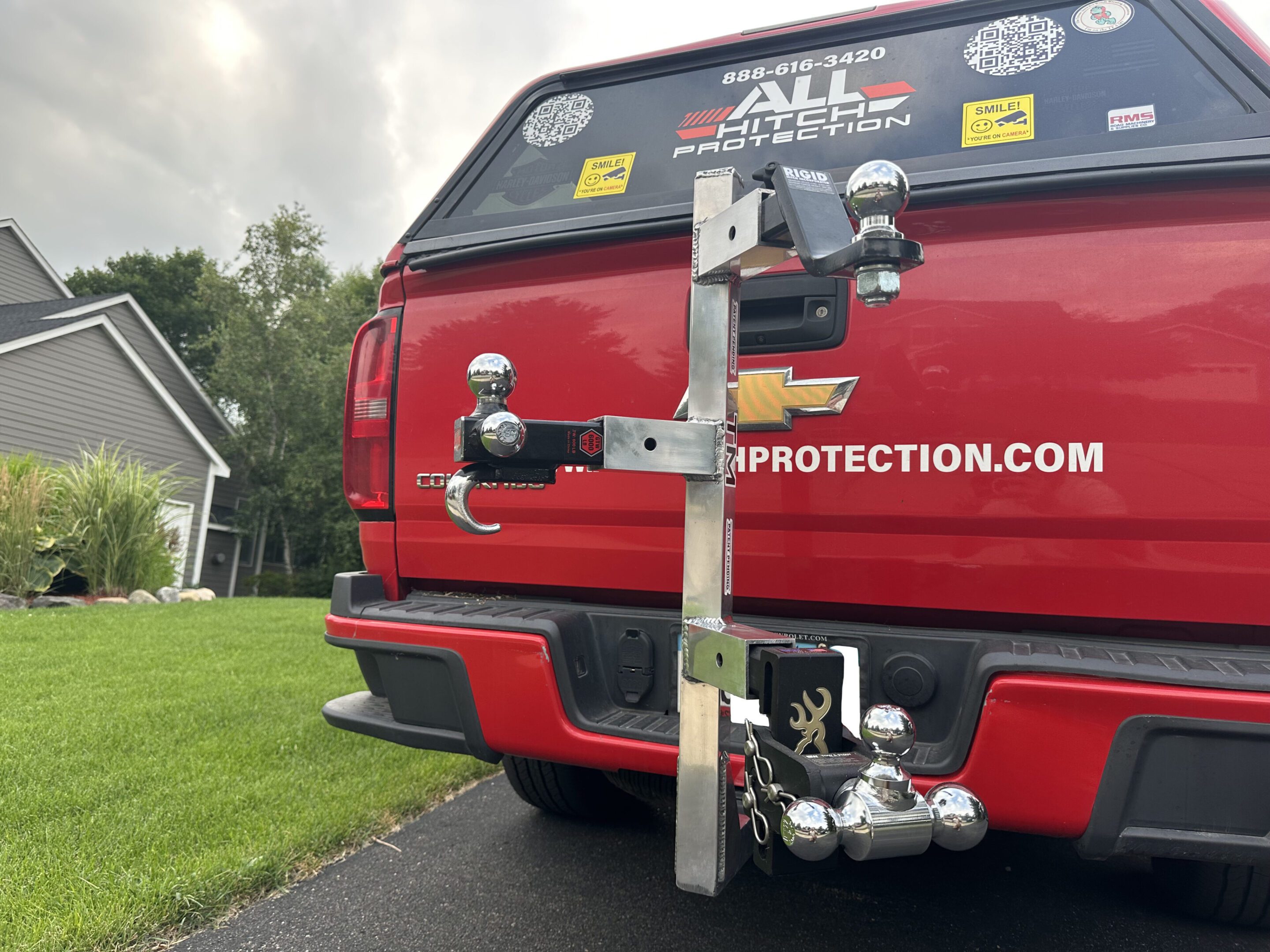 Rear view of a red vehicle equipped with a bike rack and multiple stickers.
