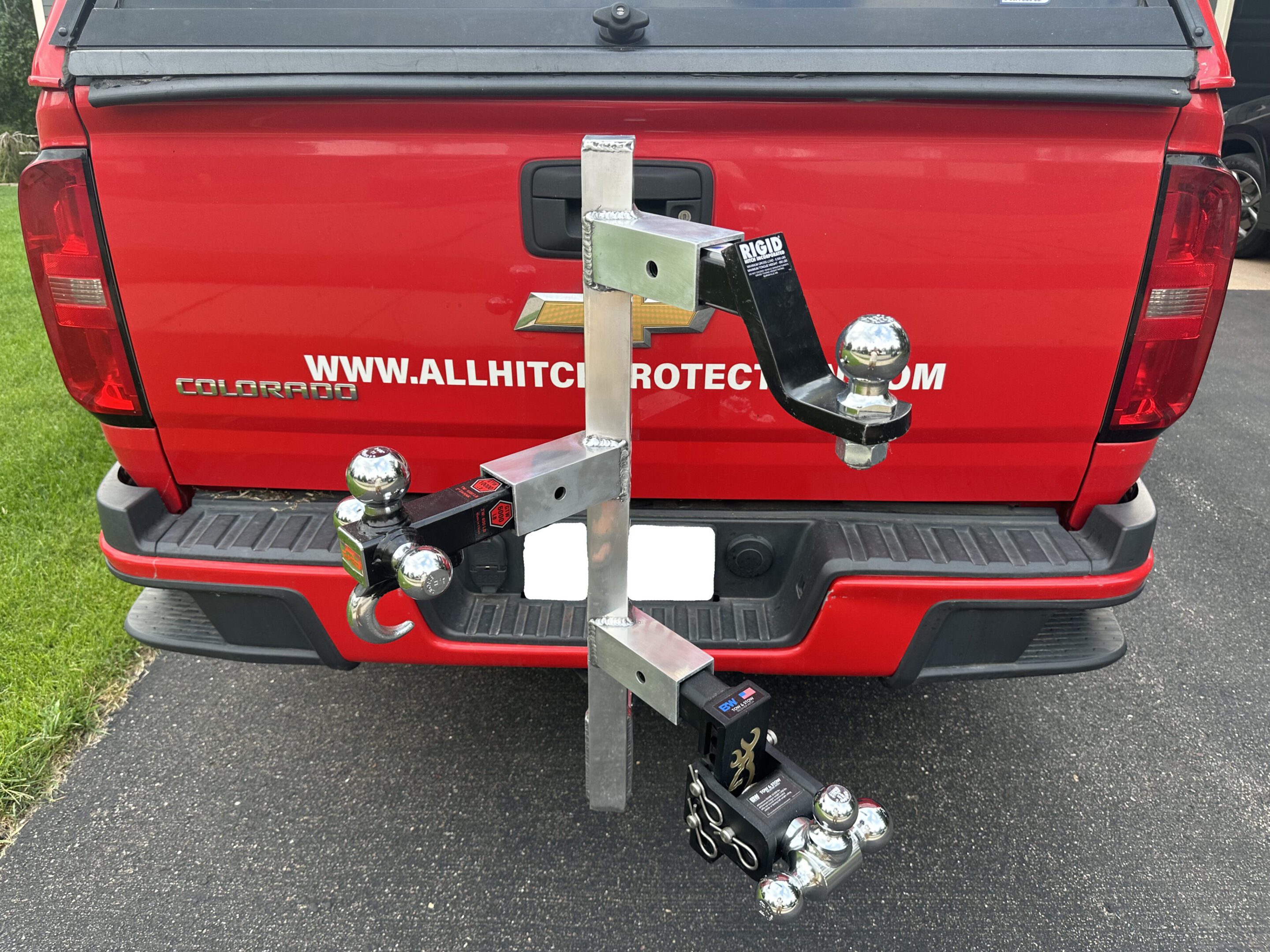 A custom hitch-mounted bike rack attached to a red vehicle.