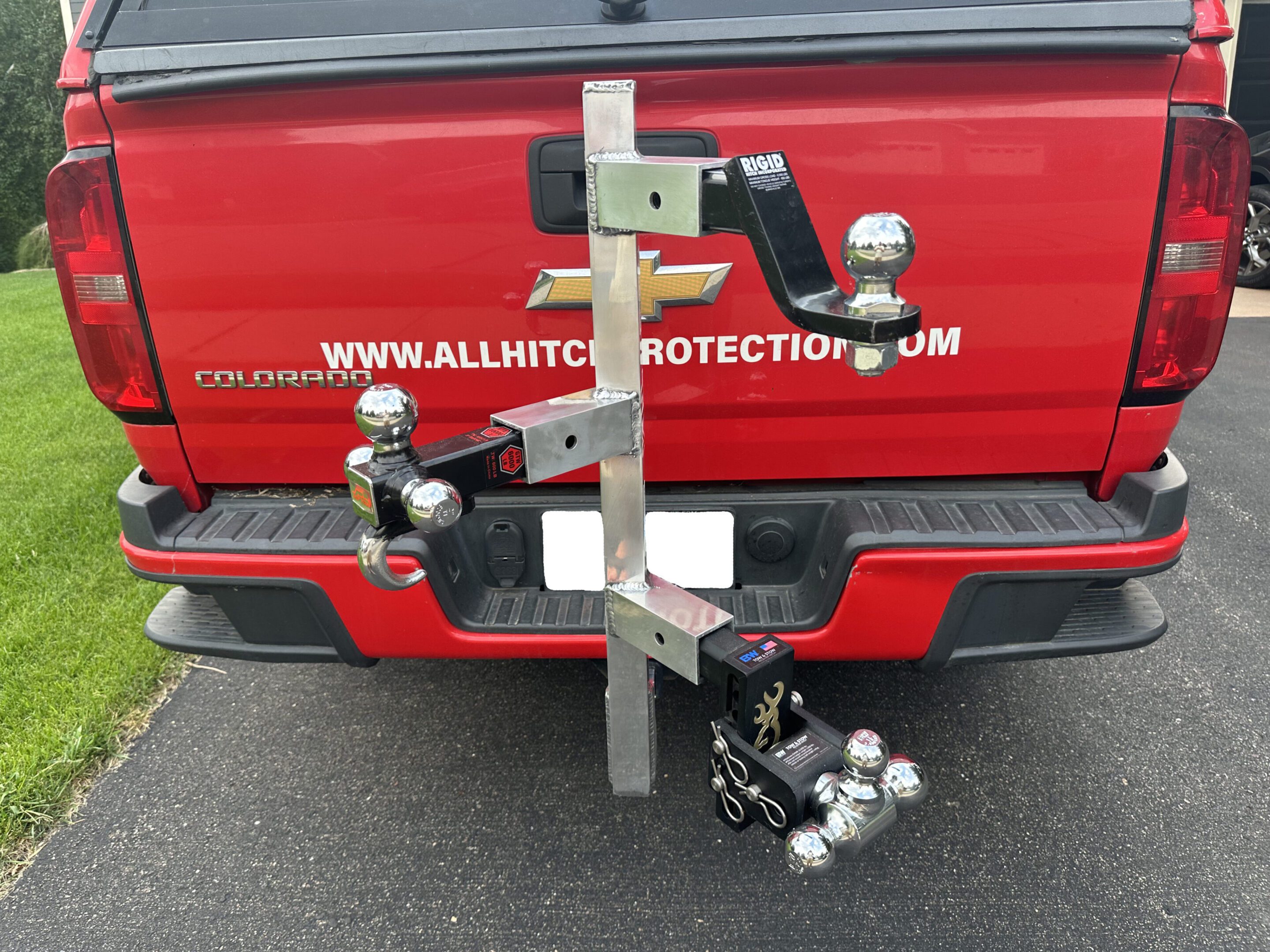 Custom hitch-mounted bike rack on a red vehicle.