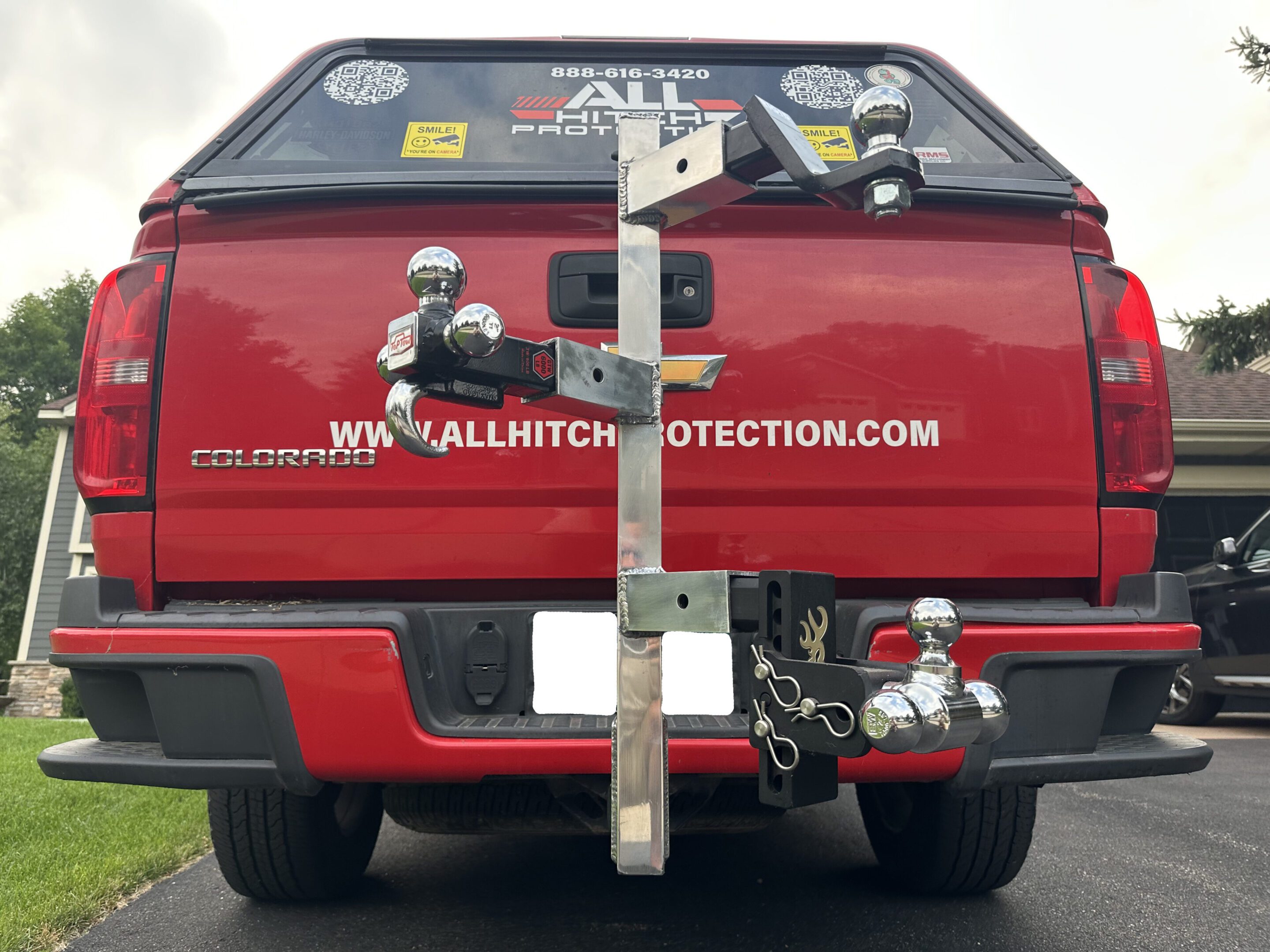 Red truck with a wooden board and various stickers on the tailgate.