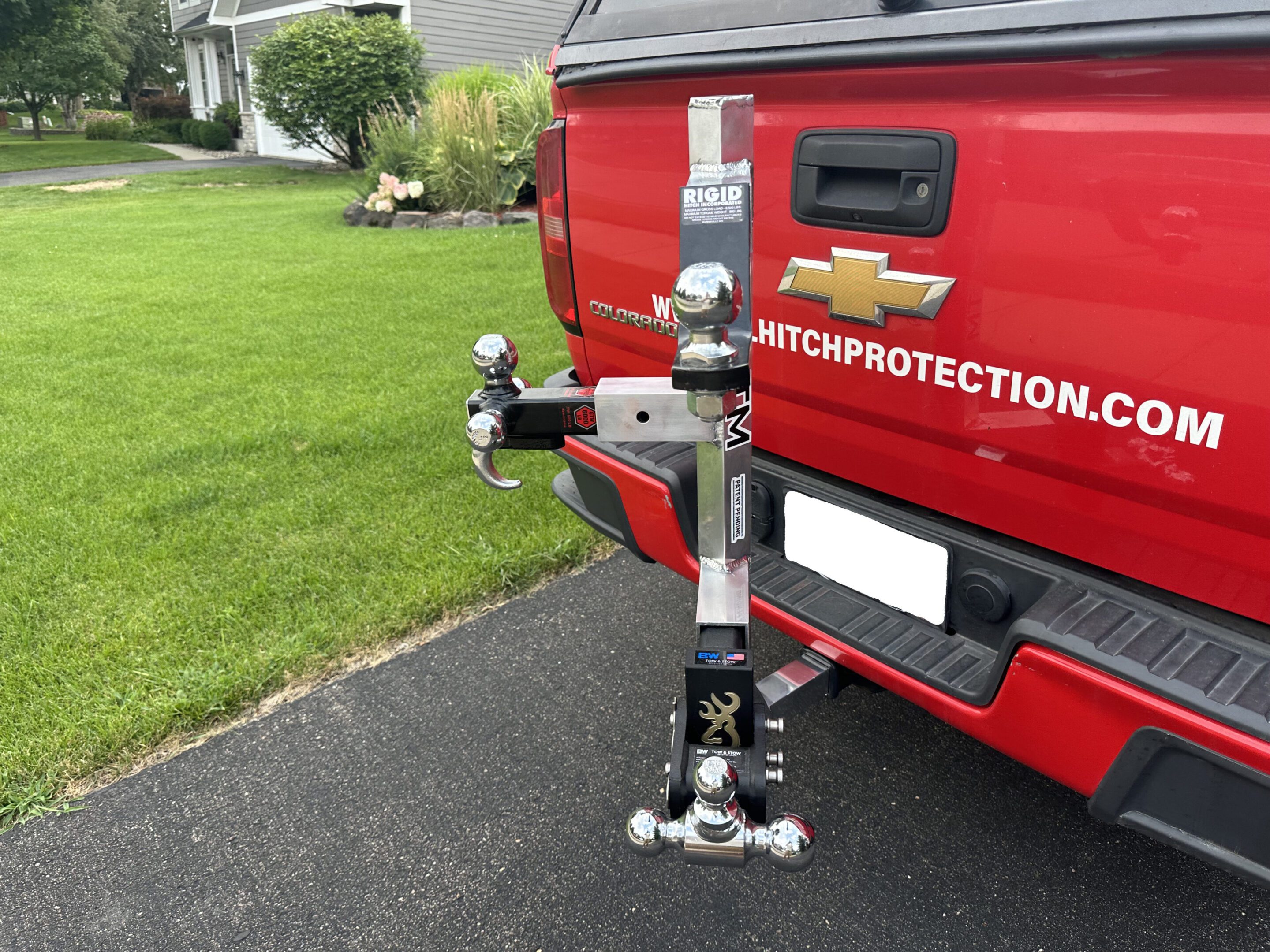 A red truck with a hitch-mounted bike rack attached to its rear.