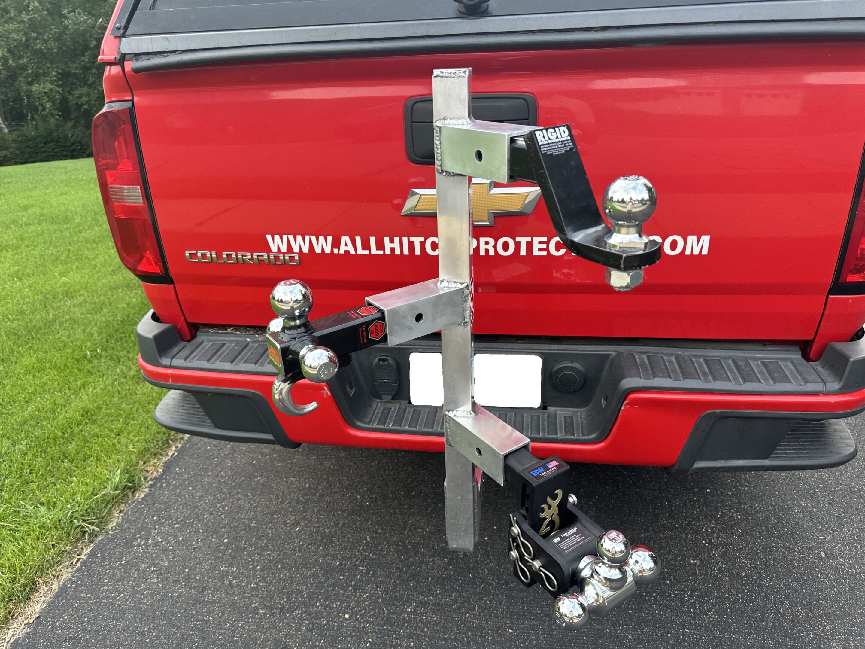 A hitch-mounted rack holding multiple trailer hitch balls of various sizes.