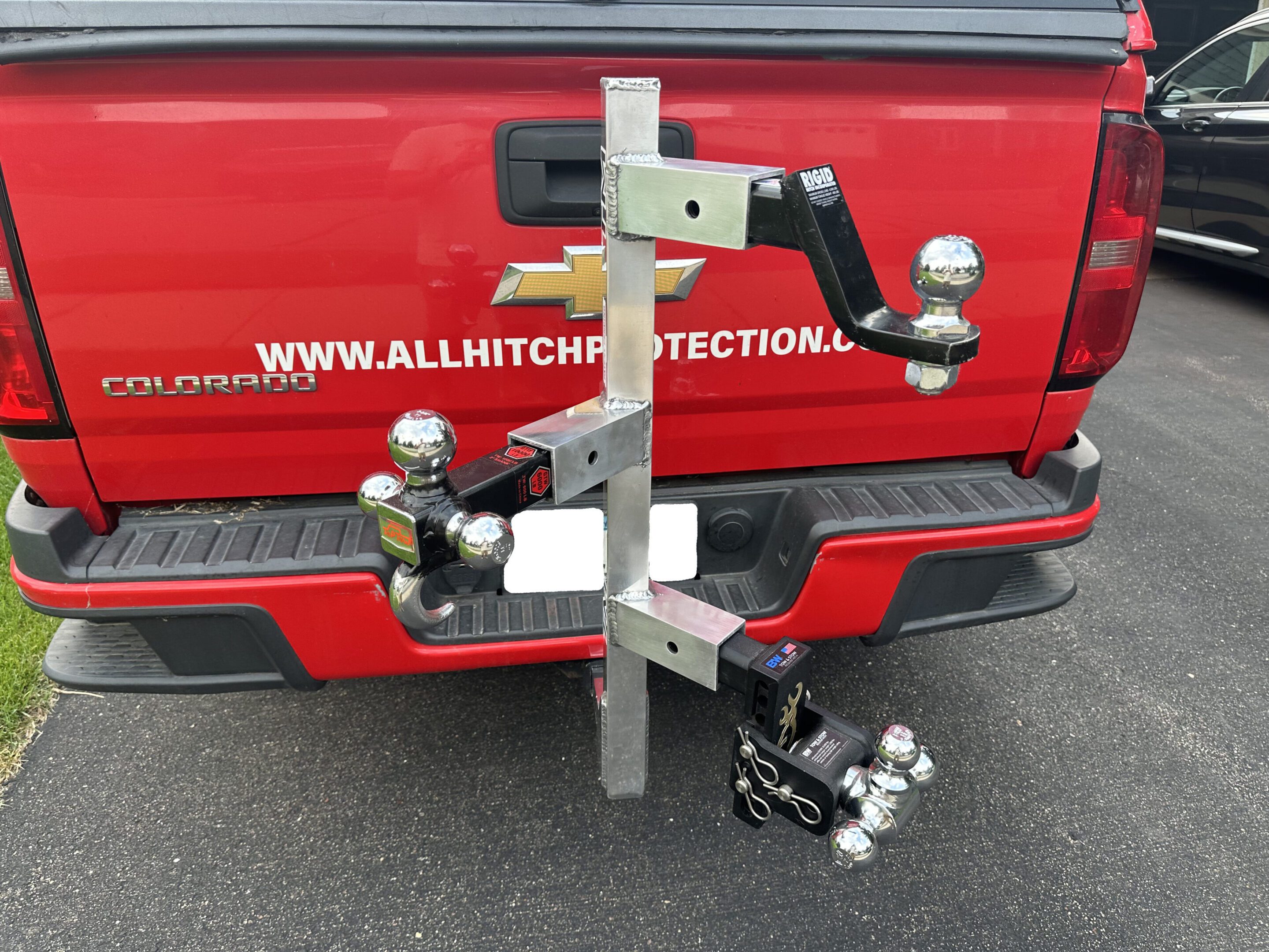 Metal hitch-mounted bike rack attached to a red vehicle.