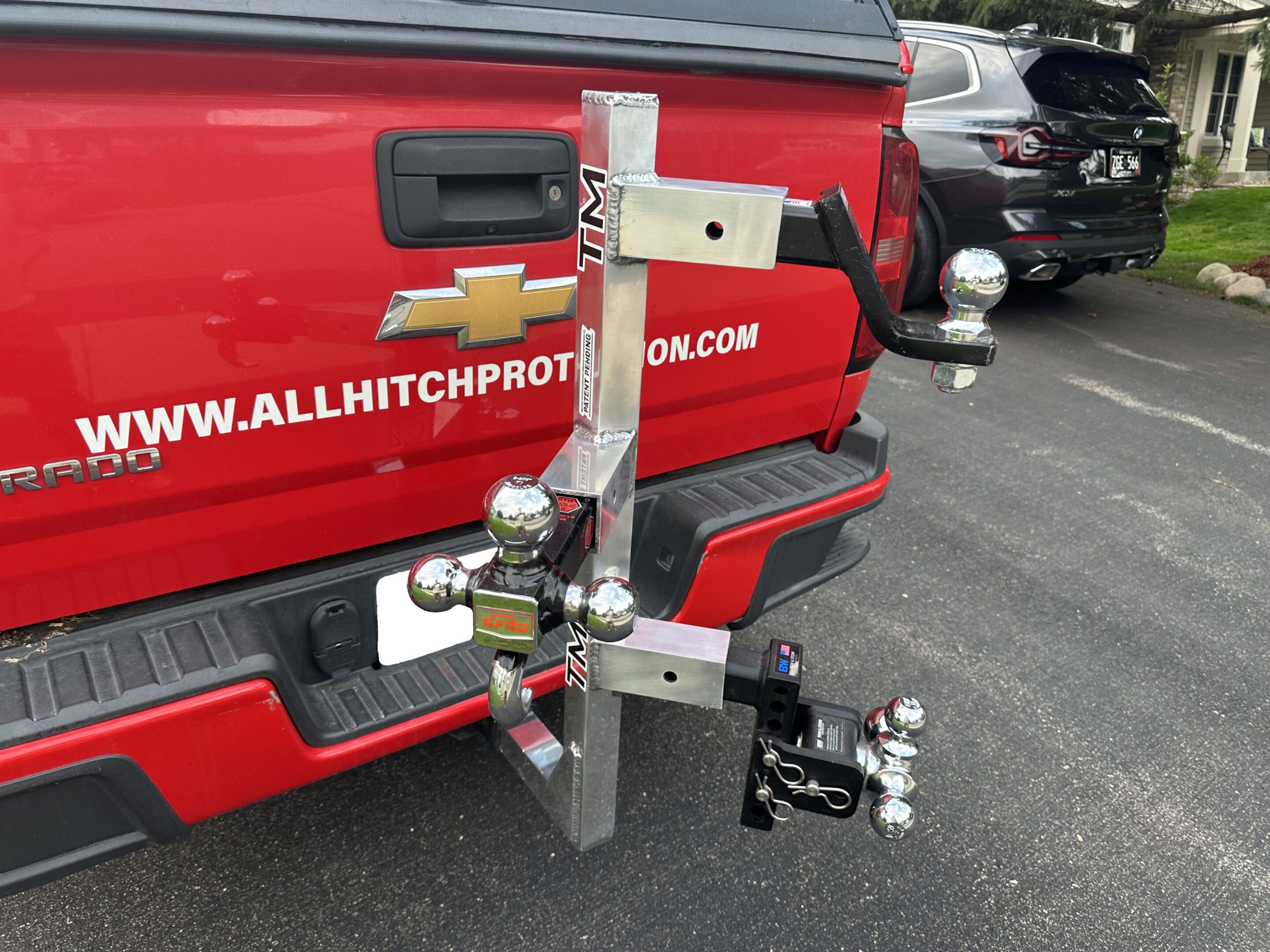 A red truck with a metal hitch accessory attached to the rear.