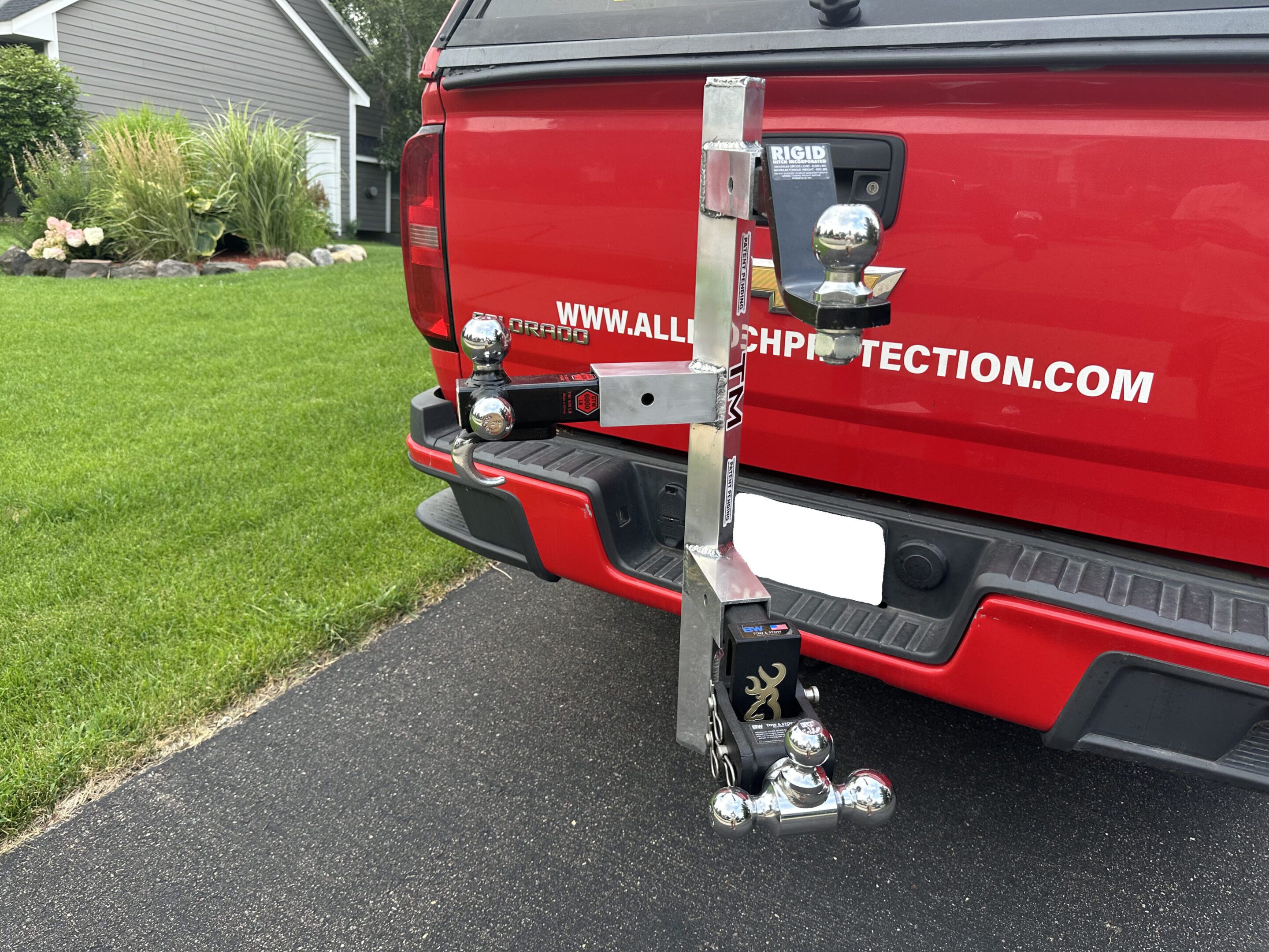 A red truck with a complex metal hitch attachment on its rear.