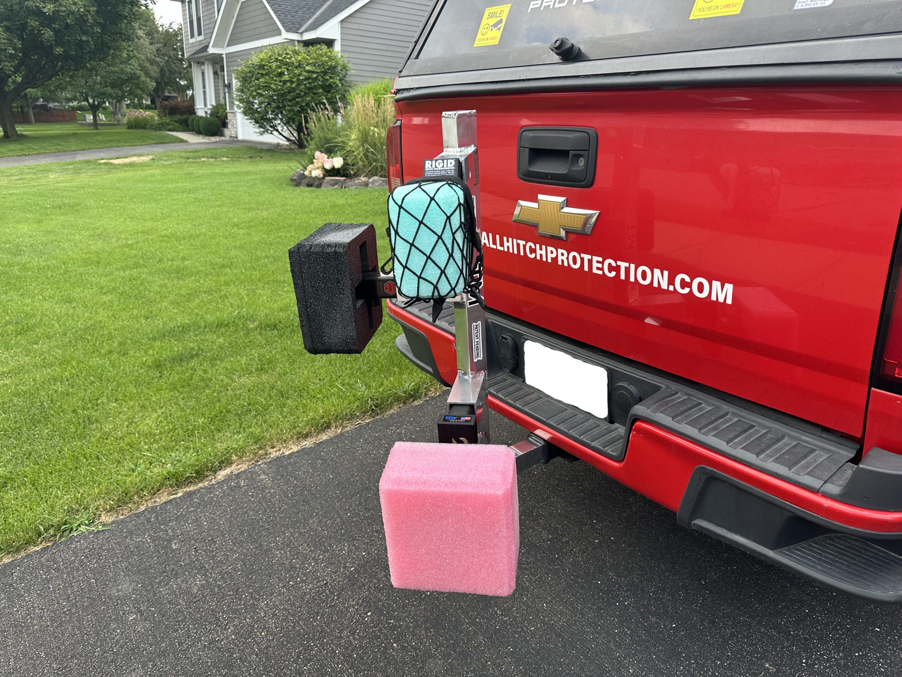 A red truck with a pink block attached to its rear.