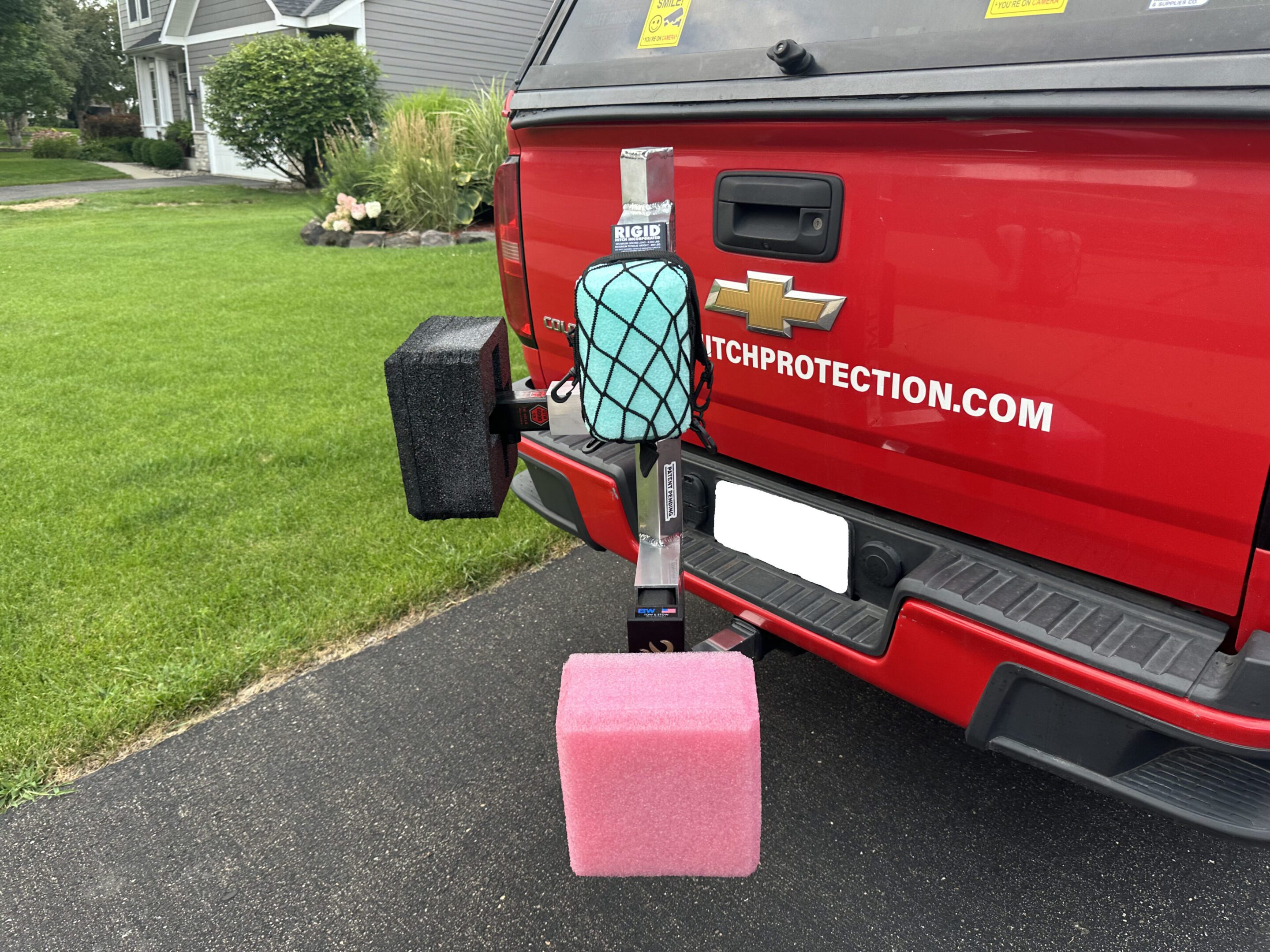 Vehicle-mounted sanitizer dispenser and container attached to a red truck.