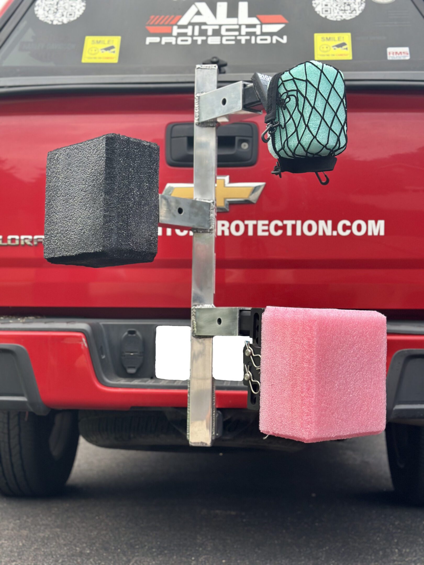 Two differently colored foam blocks attached to a metal rack on a red vehicle.