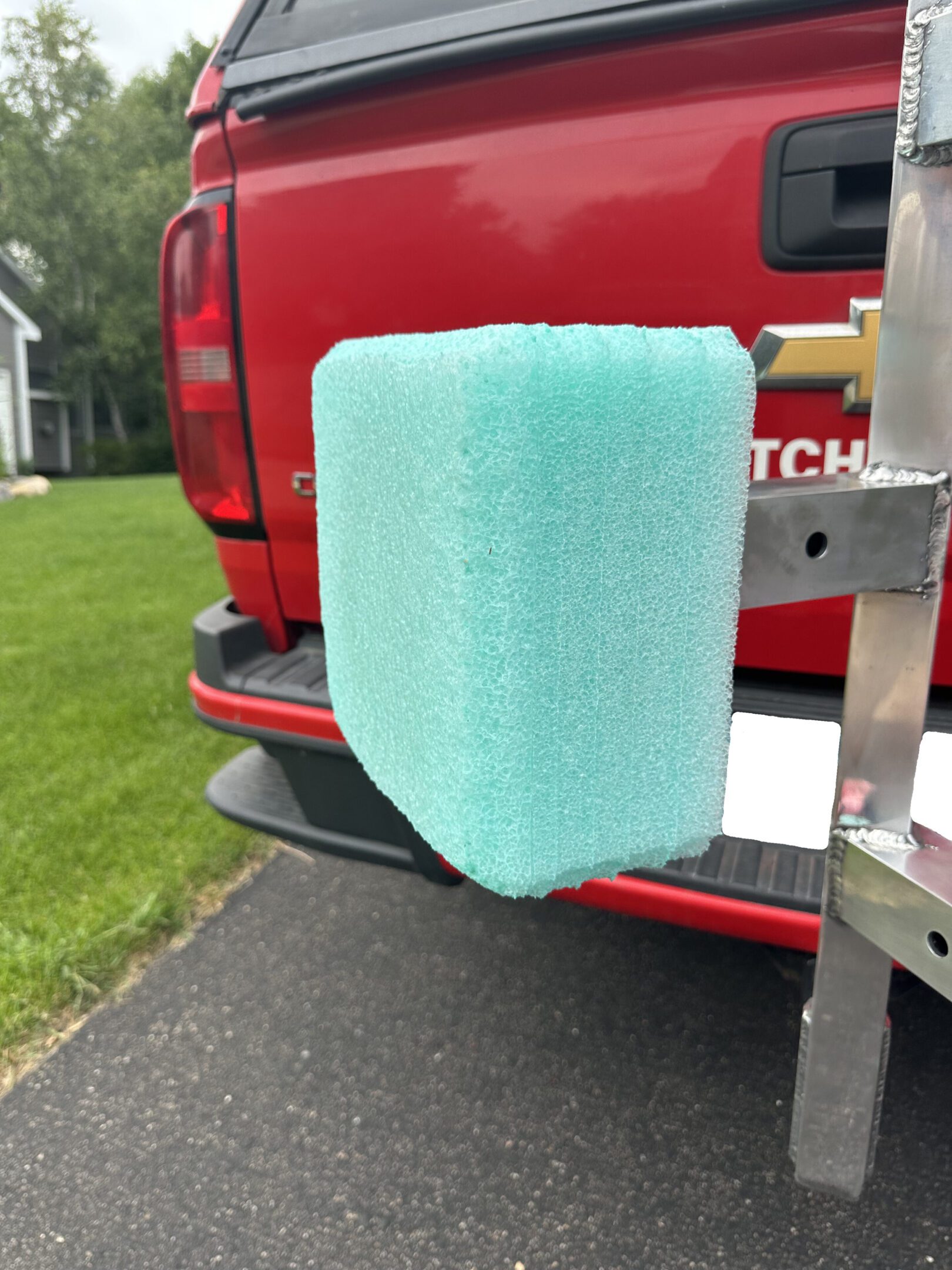 A blue foam block attached to a red vehicle's rear.
