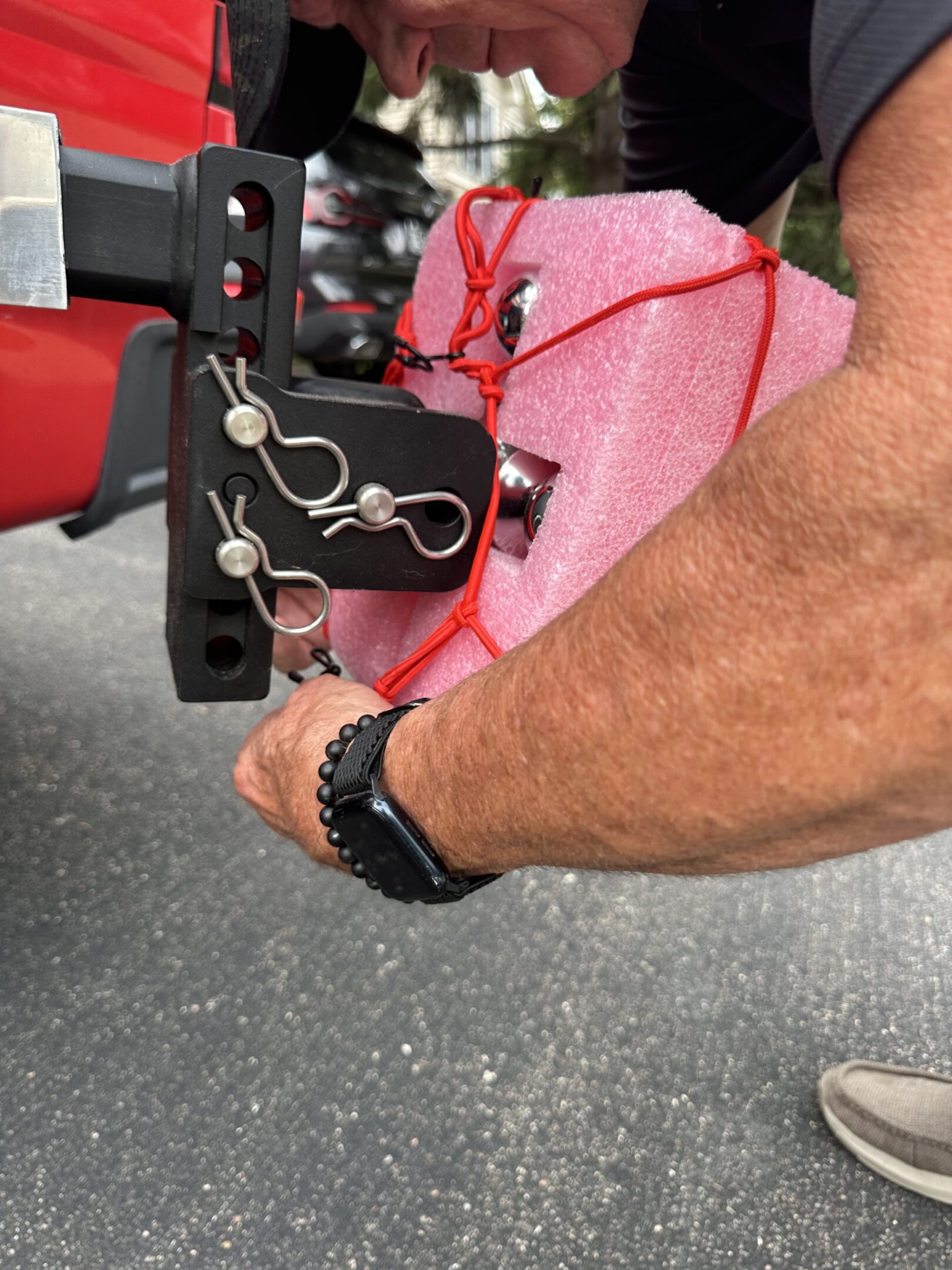 Person holding a black leather bag with keys attached.