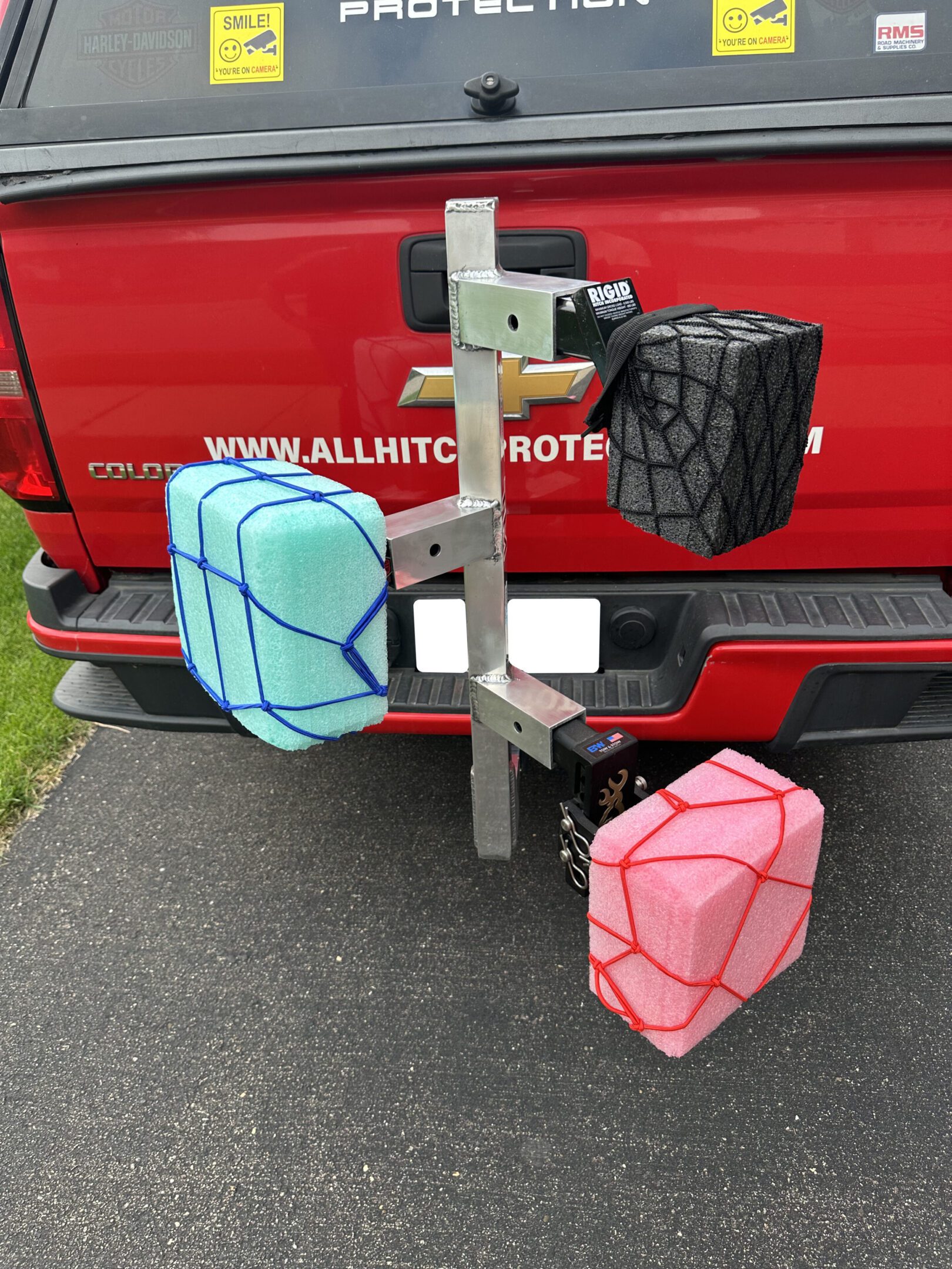 Colorful kayak floats attached to a vehicle rack on a red truck.