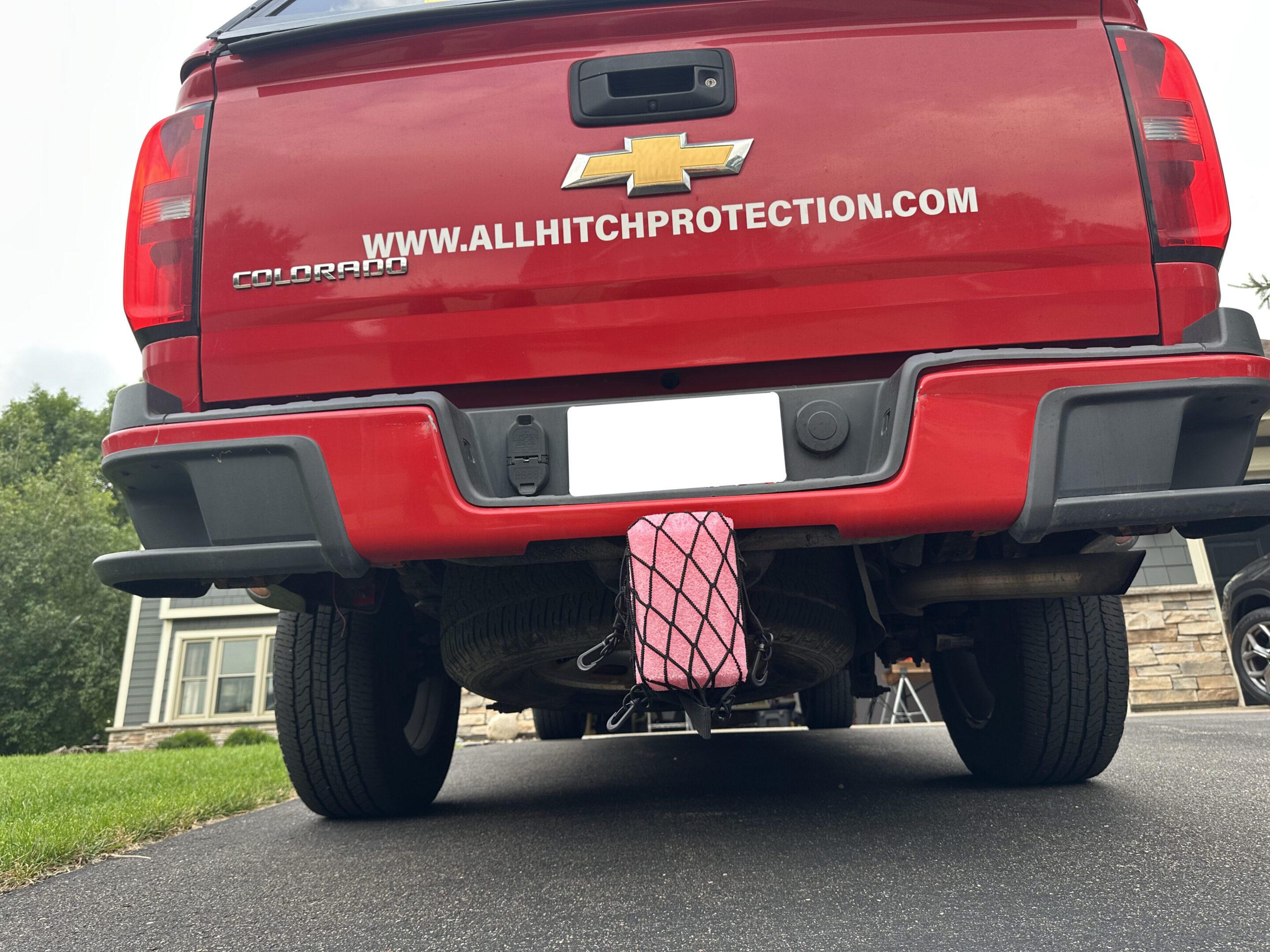 Truck with a pink diamond-patterned hitch cover.