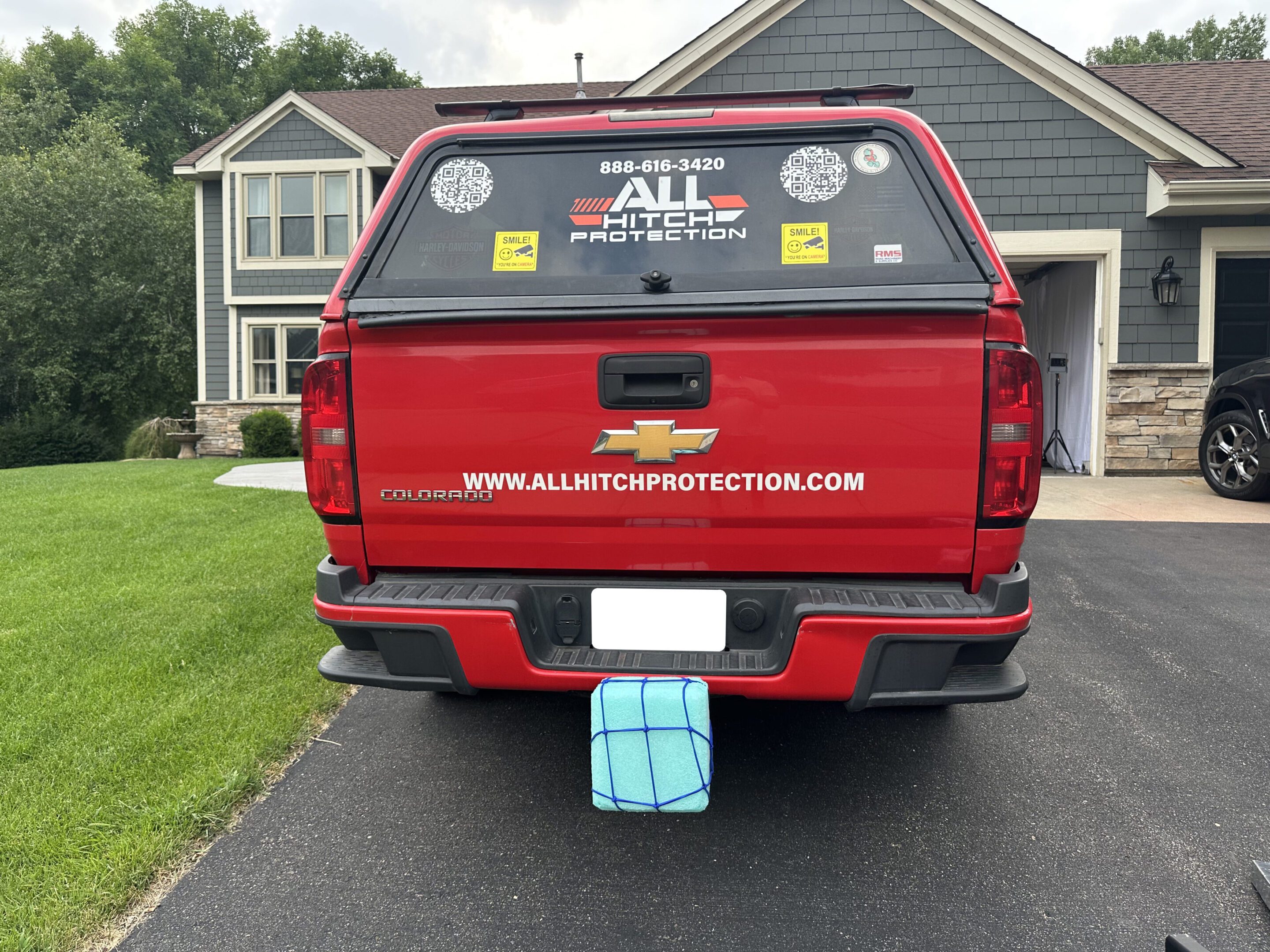 Red pickup truck with custom decals parked on a driveway.