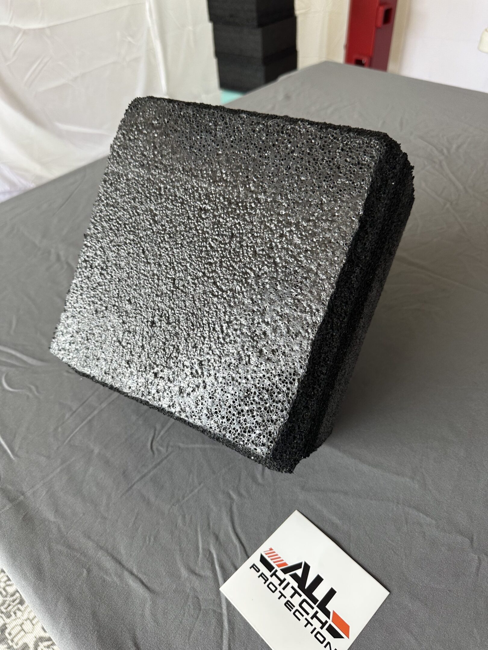 Black textured bag with a gold ring on a gray surface.