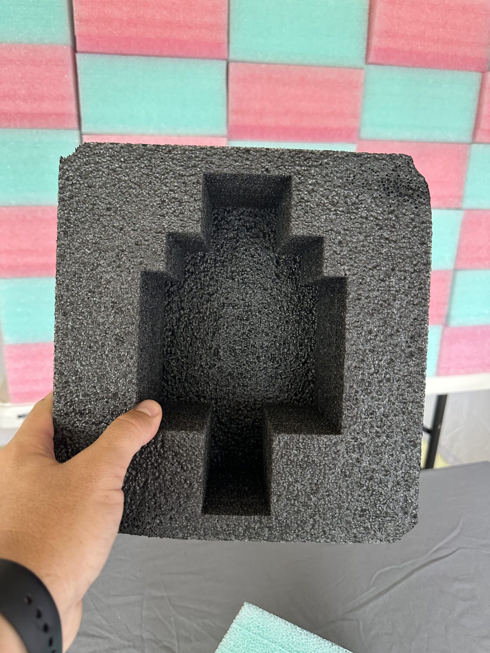 Black foam insert with custom-shaped cutouts for electronic components.