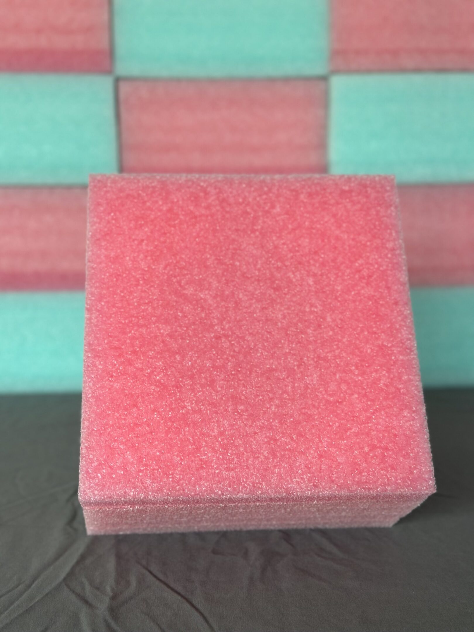 Close-up of a textured pink square tile with a matte finish.