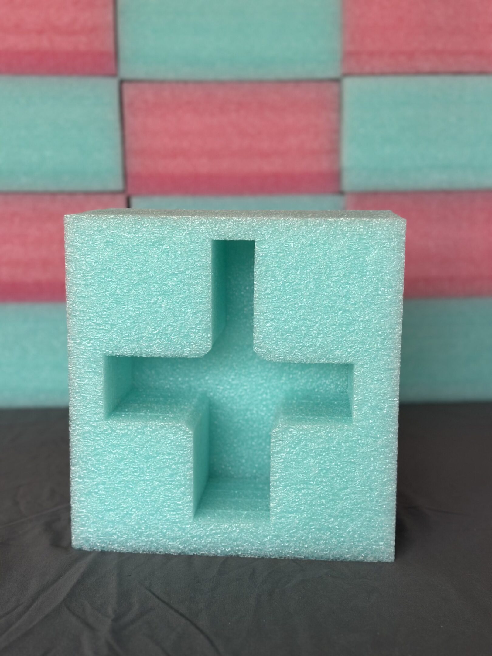 Light blue foam packaging with a cross-shaped cutout.