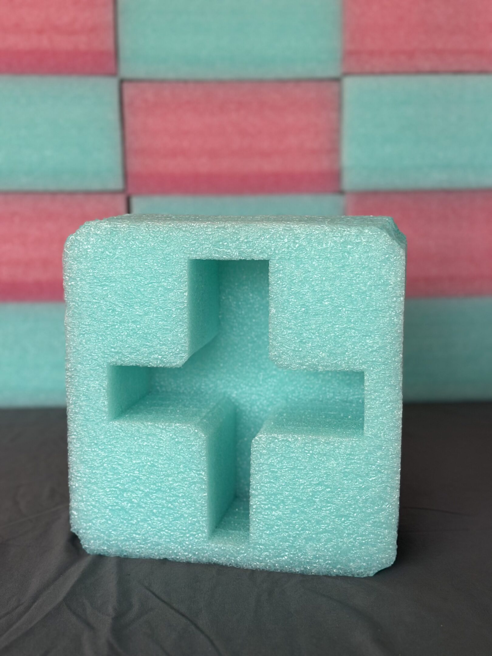 A green foam block with a cross-shaped cutout.