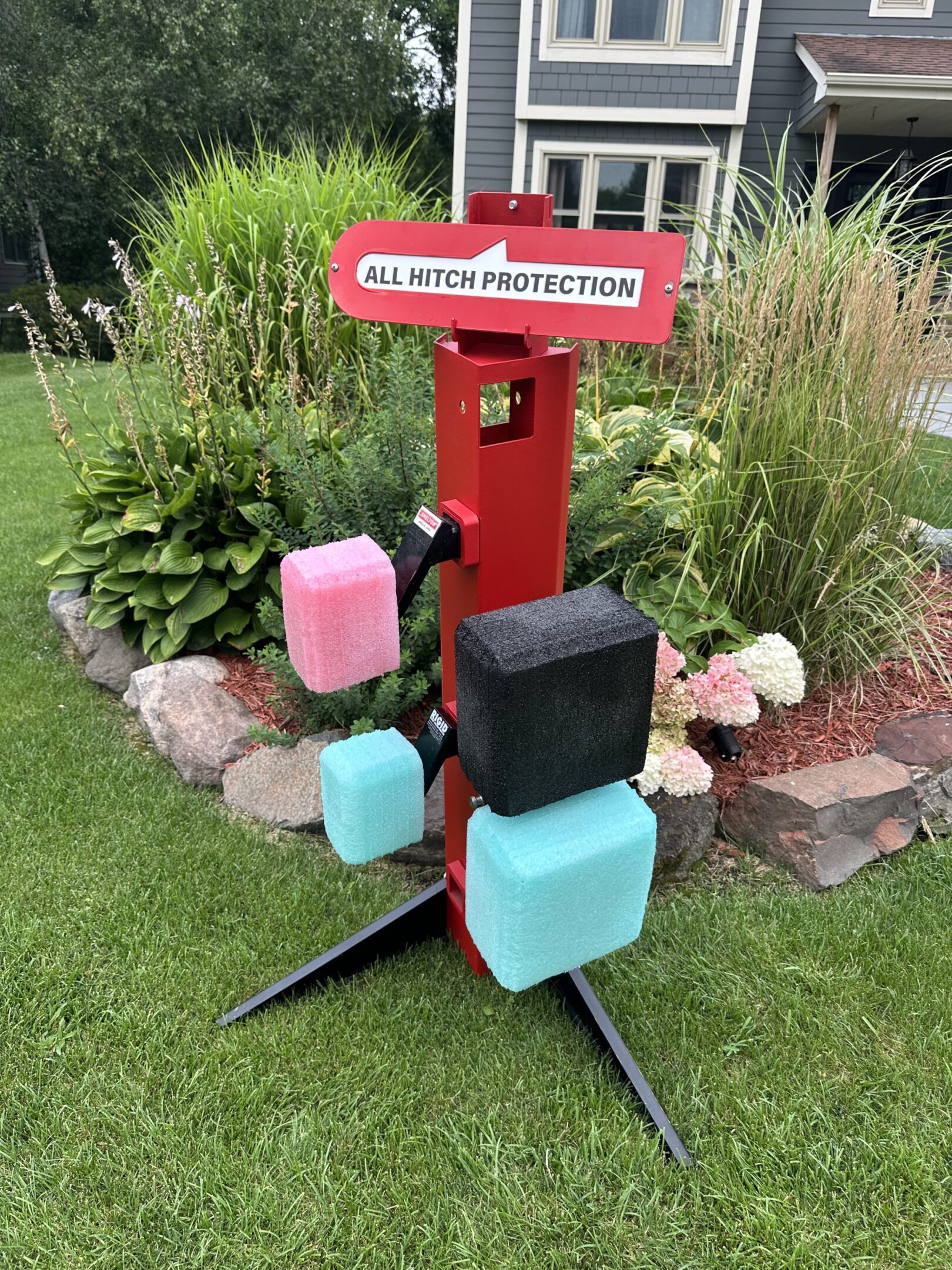 Colorful protective covers on a red suitcase stand in a garden.