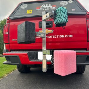 Car with large foam blocks attached to its rear bumper.